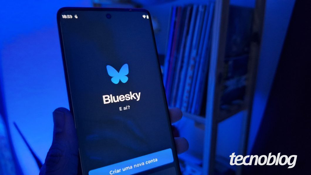 Uma mão segura um celular com o aplicativo Bluesky