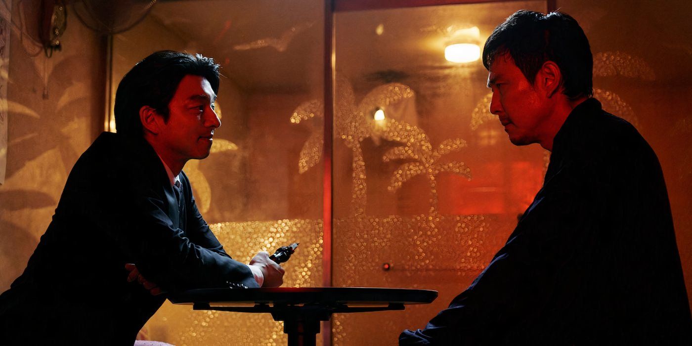 Lee Jung-jae as Seong Gi-hun aka player 456 in Squid Game sits at a table with ddjaki player