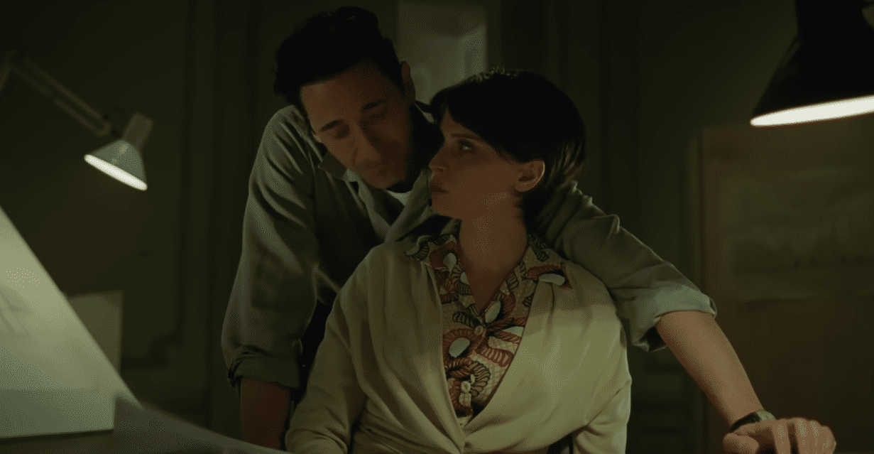 Adrien Brody e Felicity Jones abraçados em uma cena no filme O Brutalista (Imagem: Reprodução)