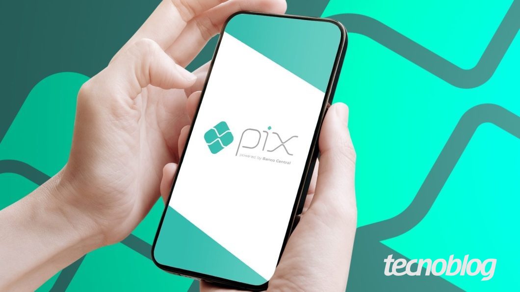 Mãos segurando um celular com o logotipo do Pix na tela